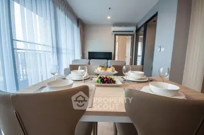 Modern dining area with elegant table setting and natural light in a stylish apartment.