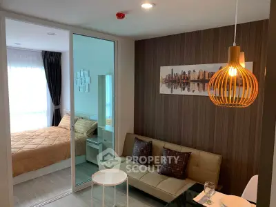 Modern apartment interior with cozy living room and stylish bedroom separated by glass partition.