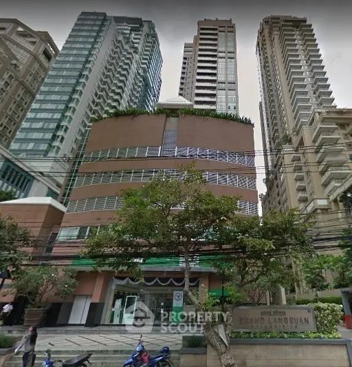 Stunning urban high-rise building with lush greenery and modern architecture in a bustling cityscape.