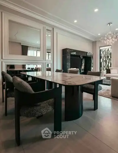 Luxurious dining area with elegant marble table and plush chairs in modern living room.
