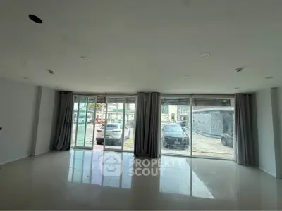 Spacious modern living room with large windows and sleek tile flooring