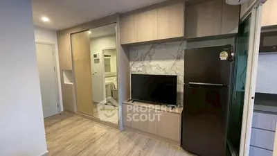 Modern apartment interior with sleek kitchen and stylish living area featuring built-in storage and TV unit.