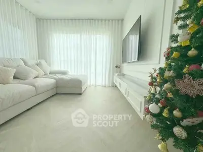 Elegant living room with cozy sofa and festive Christmas tree, perfect for holiday gatherings.