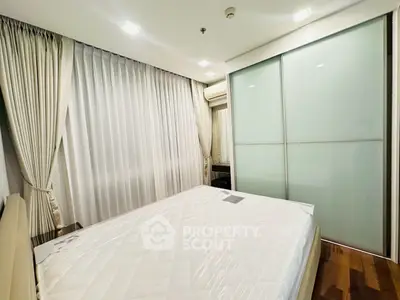 Modern bedroom with sleek design, featuring a large bed and stylish sliding wardrobe.