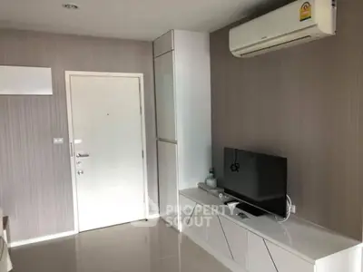 Modern living room with sleek TV unit and air conditioning in a stylish apartment.
