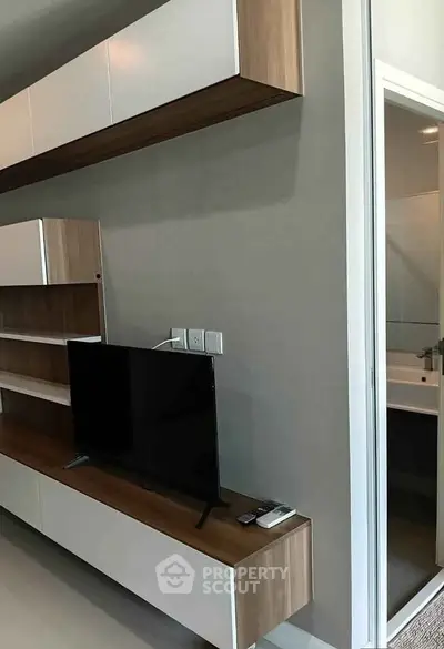 Modern living room with sleek TV unit and bathroom entrance