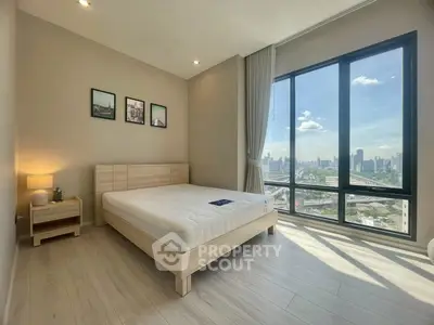 Spacious bedroom with large windows offering stunning city views and modern decor.