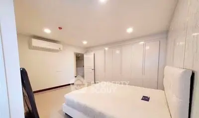 Spacious bedroom with modern design and ample closet space in a contemporary apartment.