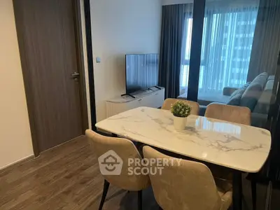 Modern dining area with marble table and plush chairs in a stylish apartment.
