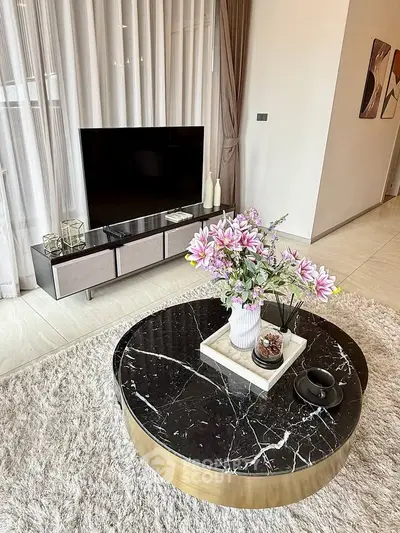 Stylish living room with modern decor, featuring a marble coffee table and sleek TV stand.