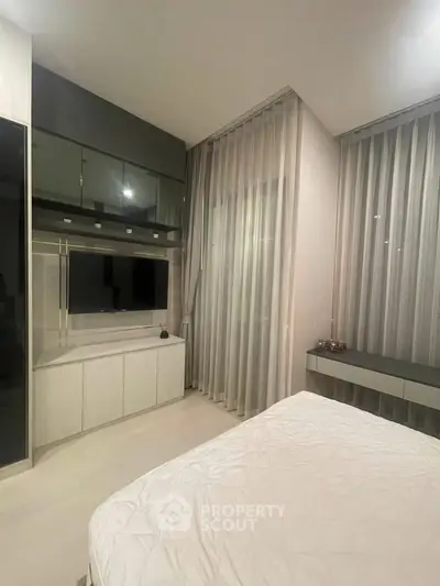 Modern bedroom with sleek cabinetry and large windows for natural light.