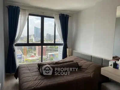 Modern bedroom with large window offering stunning city view, featuring stylish decor and cozy ambiance.