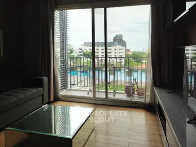 Spacious living room with pool view and large glass doors opening to balcony.
