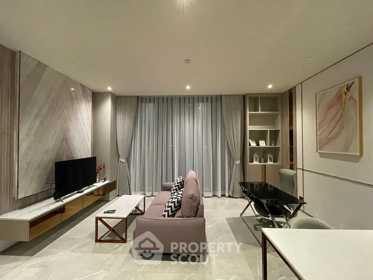 Modern living room with elegant decor, featuring a plush sofa, sleek TV setup, and stylish dining area.