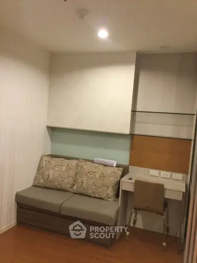 Cozy study nook with built-in desk and comfortable seating in modern apartment.
