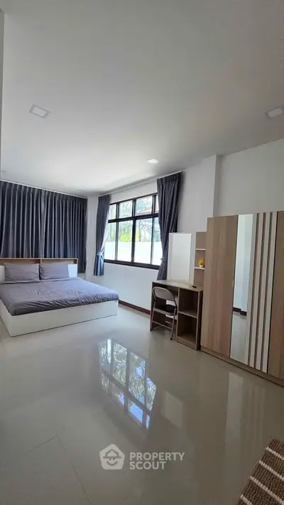 Spacious modern bedroom with large windows and sleek furnishings