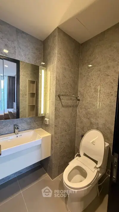 Modern bathroom with sleek design and large mirror in a contemporary apartment.