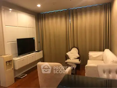 Cozy living room with elegant furniture and large TV, perfect for relaxation.