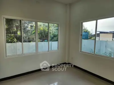 Bright empty room with large windows and garden view, perfect for customization.