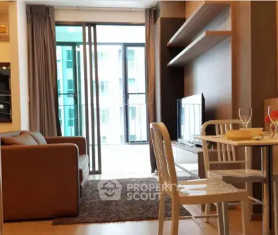 Modern living room with balcony view, stylish furniture, and dining area in a contemporary apartment.