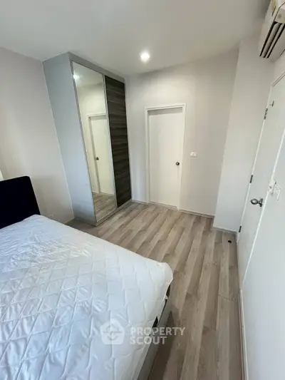 Modern bedroom with sleek wardrobe and wooden flooring