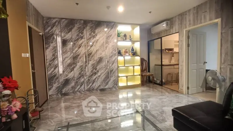 Luxurious marble-finished living room with modern decor and open kitchen view.