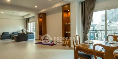 Spacious living room with elegant dining area and city view balcony
