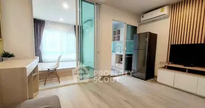 Modern open-plan living room with sliding glass doors and sleek kitchen area.