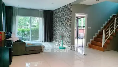 Spacious modern living room with large windows and stylish staircase