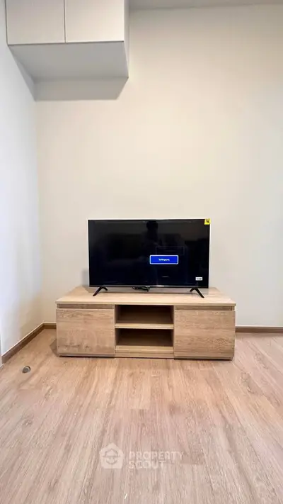 Modern living room with sleek TV stand and flat-screen TV, perfect for entertainment setup.