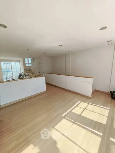 Spacious modern living room with natural light and sleek wooden flooring