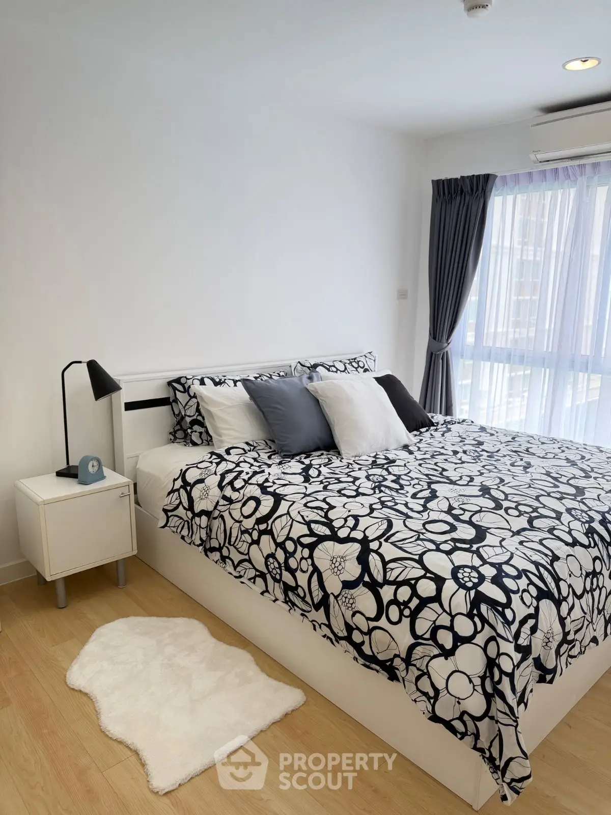 Modern bedroom with stylish decor and natural light, featuring a cozy bed and elegant furnishings.