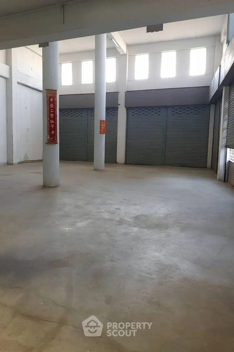 Spacious commercial property with high ceilings and ample natural light, ideal for retail or storage use.
