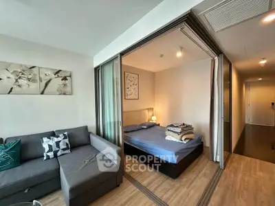 Modern apartment with cozy living room and bedroom, featuring stylish decor and wooden flooring.
