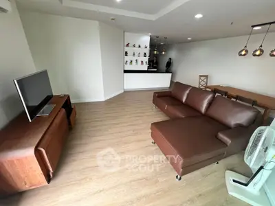 Spacious living room with modern brown leather sofa and stylish wooden furniture