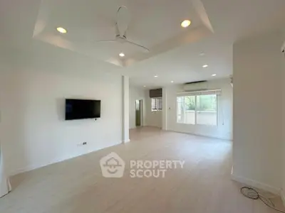 Spacious modern living room with ceiling fan and wall-mounted TV