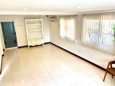 Bright and spacious living room with large windows and elegant tile flooring.