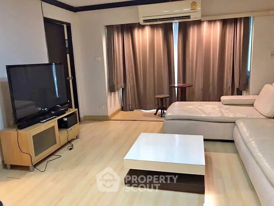 Spacious living room with modern furniture and large TV setup