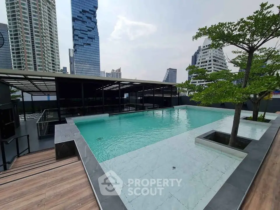 Luxurious rooftop pool with stunning cityscape views in modern high-rise building.