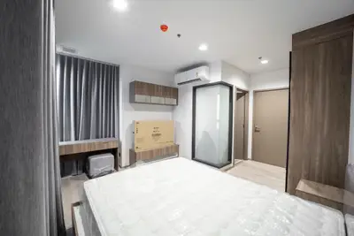 Modern bedroom with sleek design, featuring a large bed, air conditioning, and stylish wooden furniture.