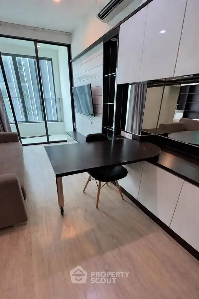 Modern living room with sleek furniture and large windows offering natural light
