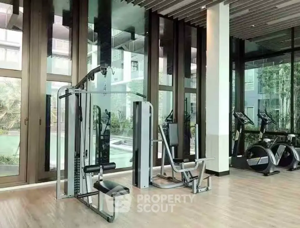 Modern gym with state-of-the-art equipment and large windows offering a garden view.