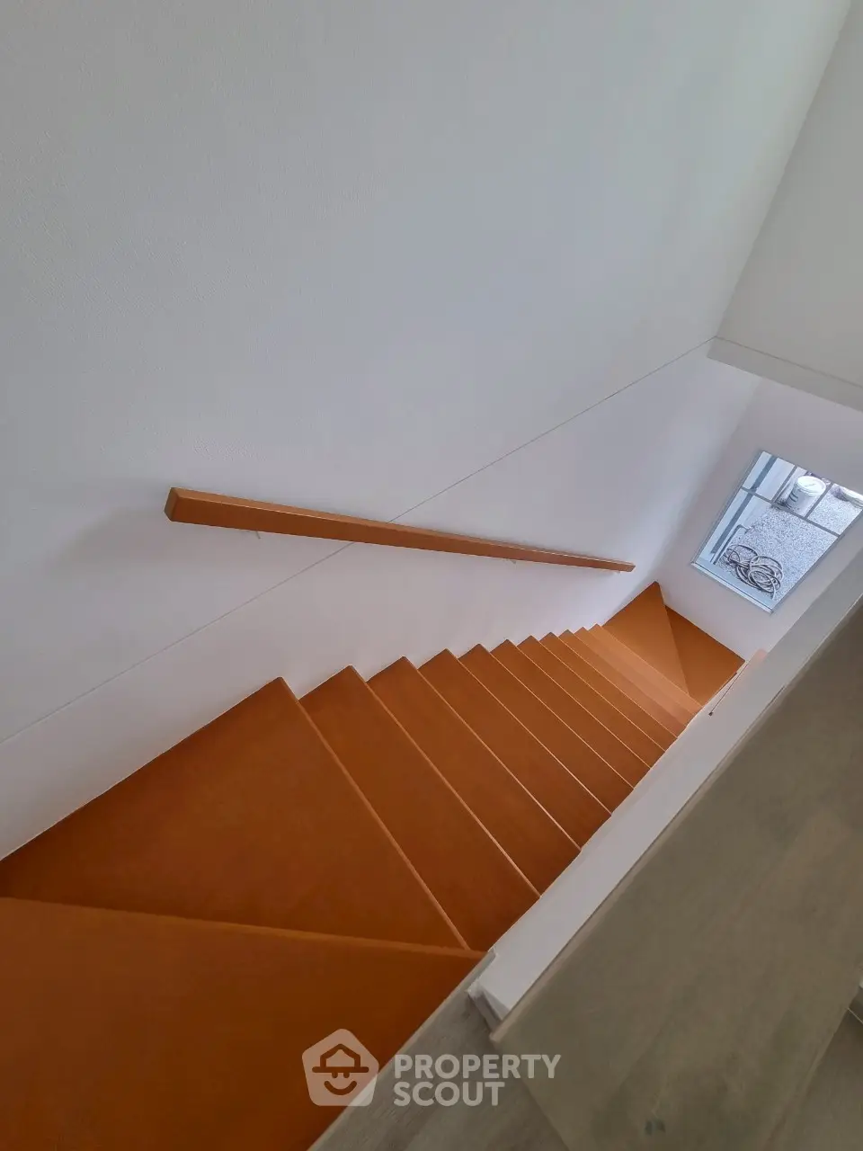 Modern staircase with sleek design and natural light from window