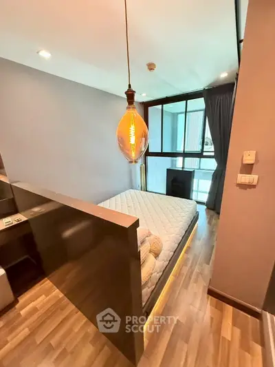 Modern bedroom with stylish lighting and large window in a contemporary apartment.