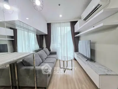 Modern living room with sleek design, featuring a comfortable sofa, large TV, and stylish decor.