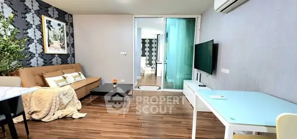 Modern living room with stylish decor and open layout, featuring a cozy sofa and sleek TV setup.