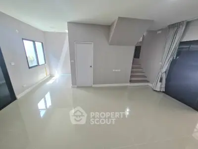 Spacious modern living room with sleek staircase and large windows