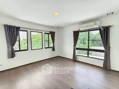 Spacious empty room with large windows and air conditioning, offering a bright and airy atmosphere.