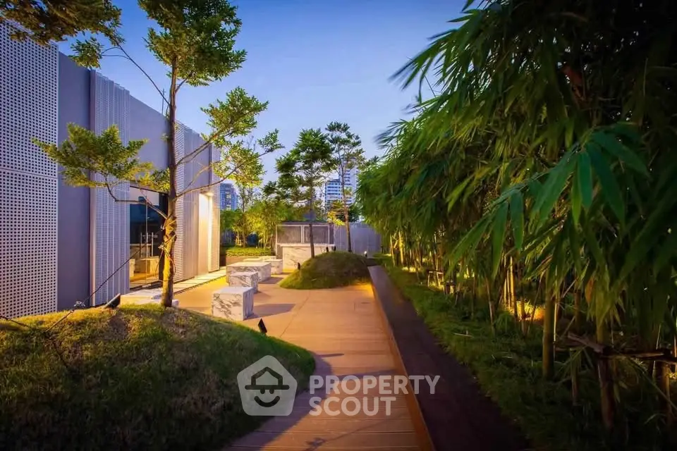 Luxurious garden pathway with modern landscaping and ambient lighting in a high-end residential complex.