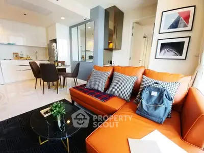 Modern living room with orange sofa and stylish decor in open layout apartment.